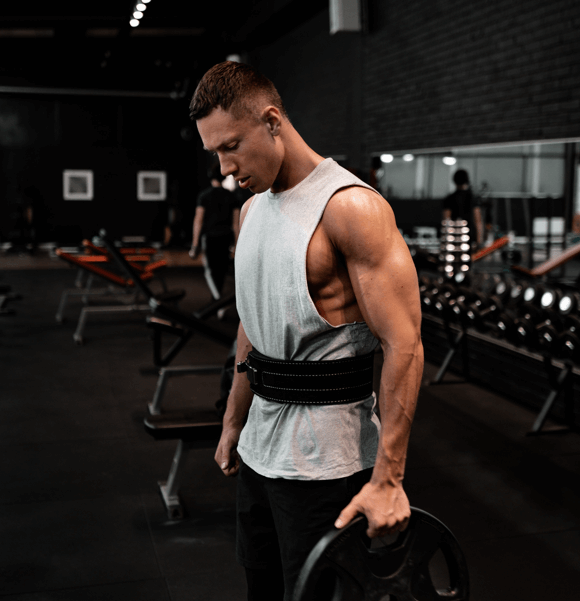 Photo d'exercice de lainage avec poids en position debout fait avec ceinture abdominale à la salle de 3X15.